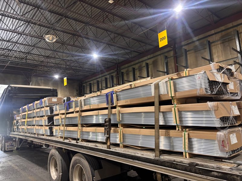 Aluminum extrusion bundles strapped on a Fission flatbed at the loading dock